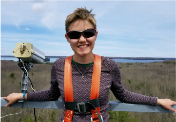 Erica McCormick standing by an eddy covariance tower in Michigan.